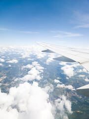 Obraz premium View from an airplane window looking out over beautiful clouds and blue sky during flight.