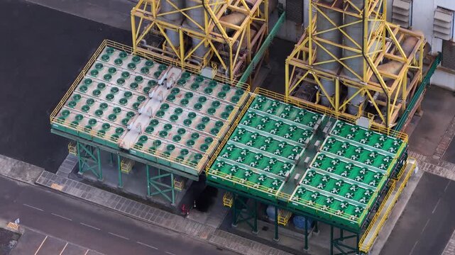 Aerial view of industrial cooling towers and yellow steel structures at the Tecnovia Acores facility in Rabo de Peixe, Acores, Portugal.