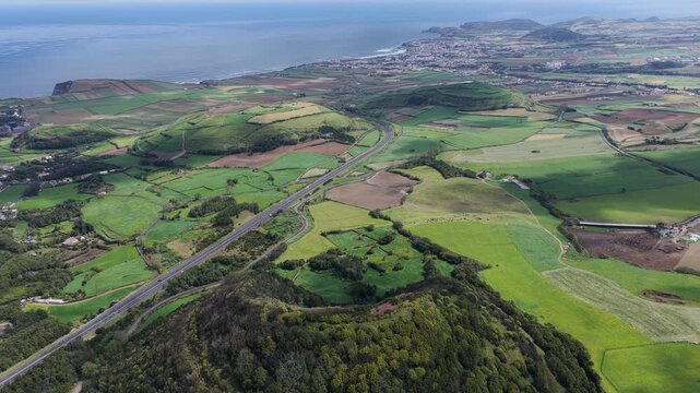 Aerial view of the lush green volcanic landscape and rolling hills near the coastline in Rabo de Peixe, Acores, Portugal.