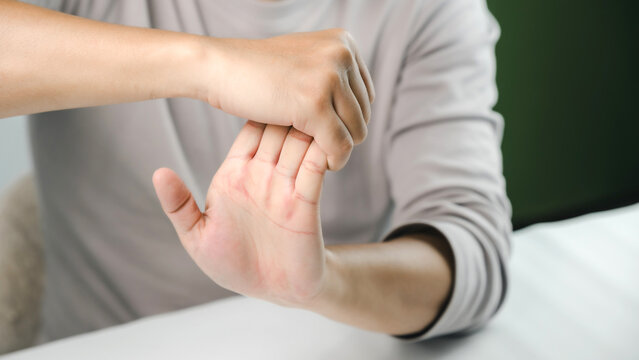 Close-up of a person stretching the wrist and hand to relieve stiffness, improve flexibility, and prevent repetitive strain injury, supporting physical therapy, rehabilitation, fitness, and wellness.