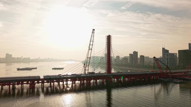 Aerial view of bridge sections being dismantled with a large crane over a river