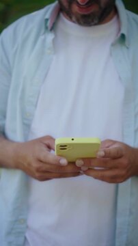 Unrecognizable man texting on modern smartphone