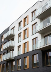 Obraz premium Contemporary Urban Apartment Block with White and Black Brick Exterior and Glass Balconies
