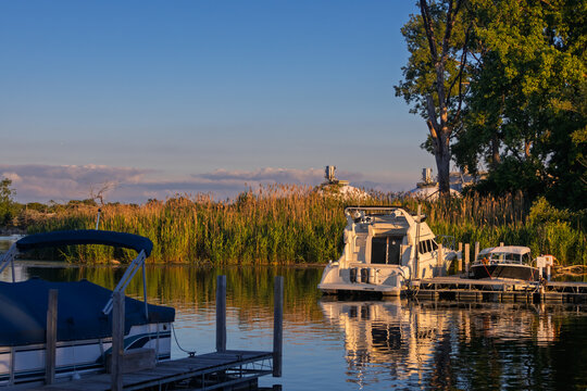 Boats moored at marina dock during golden hour sunset