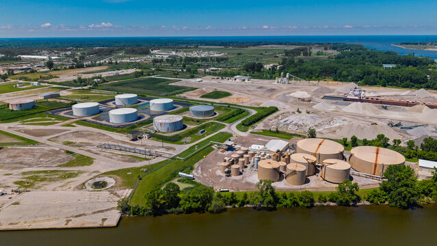 Aerial view industrial facility storage tanks riverfront infrastructure in Michigan