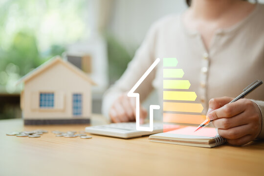 Home energy efficiency calculation with house model, calculator and energy rating scale, illustrating renewable energy planning, cost savings, ROI analysis, and sustainable property investment.