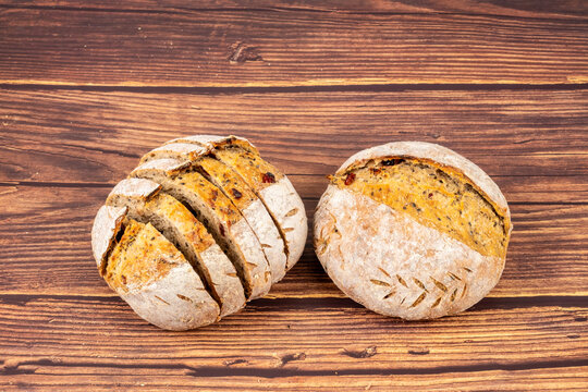 Freshly baked sourdough bread loaf on the wooden and white background with full depth of field. Artisanal or healthy food concept