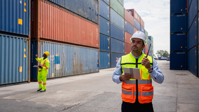 Port worker using a radio transceiver to control a crane loading container boxes onto a cargo ship, representing sea transportation and logistics business concepts
