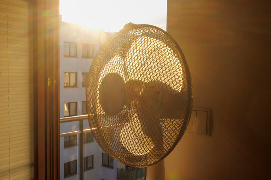 Electric fan ventilating a room on a hot summer morning.
