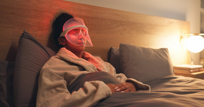 Woman, relax or light with uv mask in bed for facial, skincare or anti aging treatment in home. Beauty, female person or red LED cosmetics for skin protection, collagen or blood circulation in house