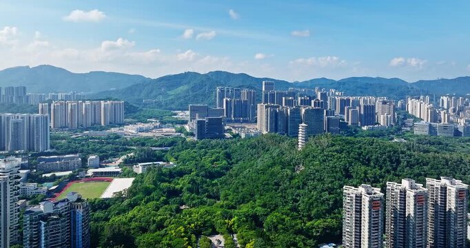 Aerial view of a traditional white pagoda surrounded by a lush green forest park in Shenzhen, China