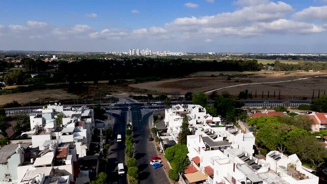 Forward Flying Drone From Rehovot Residential Buildings Toward Open Fields and Distant Ashdod Skyline Under Clear Blue Summer Sky in Central Israel
