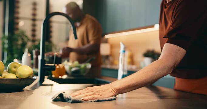 Cleaning, cooking and hands of couple in kitchen for help, meal prep and share tasks for marriage. Housework, counter and man with woman in home for disinfection, wipe or hygiene with food for dinner