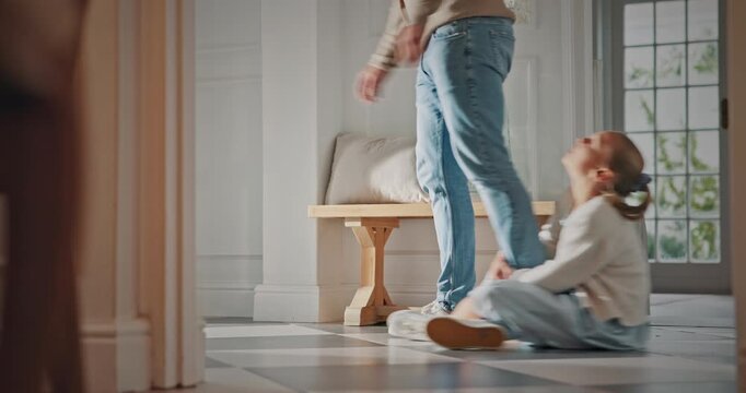Legs, father and kid with clingy in home for separation anxiety, dependence or sad for leaving. Attachment, dad and dragging child on floor for physical connection, attention and fear of abandonment