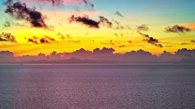 Vibrant orange clouds over the calm sea horizon at sunrise in Zhuhai, China