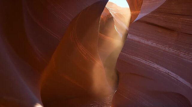 In a Danxia landform canyon, intense afternoon light pierces through the narrow crevices; suspended red-soil dust is drawn into the beams, forming spiraling columns of light that slowly twist