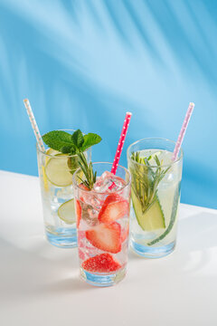 Set of fresh non alcoholic drinks with strawberry cucumber and lemon on blue background
