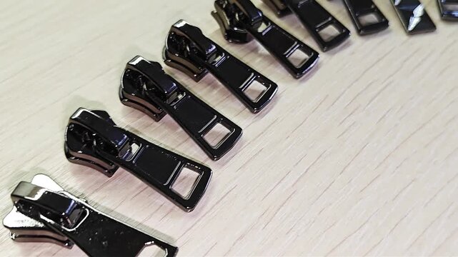 Black Metal Zipper Sliders for Sewing and Bag Making.Ideal for themes of tailoring, sewing supplies, fashion accessories, craftsmanship, and haberdashery.