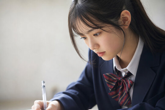 真剣な表情で勉強する女子高生