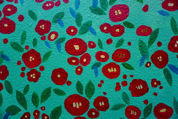 Colorful mural of red camellia flowers painted on a textured wall © Hyeyun