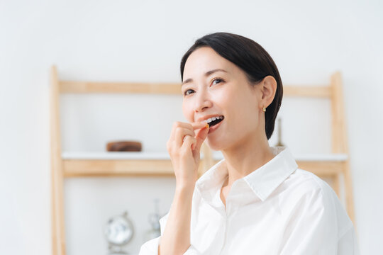 薬を飲む女性。医薬品、サプリメント、常備薬、ジェネリック、ビタミン剤、風邪薬、頭痛薬、便秘薬