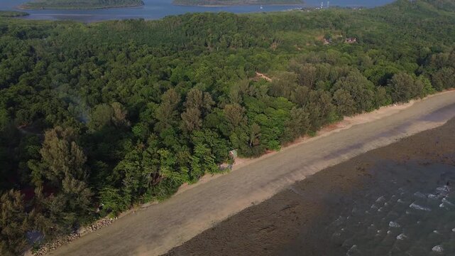 Cinematic aerial footage capturing tropical islands rising from the Andaman Sea near Koh Jum in Krabi Thailand. Lush green forest and peaceful coastal scenery create a premium travel destination view