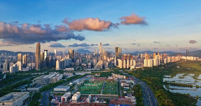 High angle view of modern sports complex and urban skyline with highway at sunset in Shenzhen, China