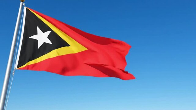 Flag of east timor waving against a clear blue sky