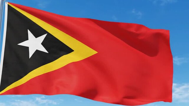 Flag of east timor waving in the wind against a clear blue sky