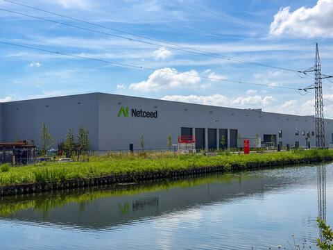 Netceed telecommunications distribution warehouse exterior with canal reflection in Rijkevorsel, Belgi&euml;