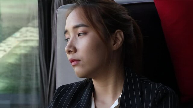 sad young asian businesswoman looking out window at urban pond during work break, sighing with frustration and exhaustion