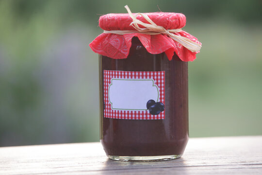 Jar of homemade plum jam with blank label,