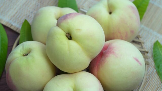 White Peaches with leaves on the wooden table, Fresh White Peach on wooden basket in wooden Background.