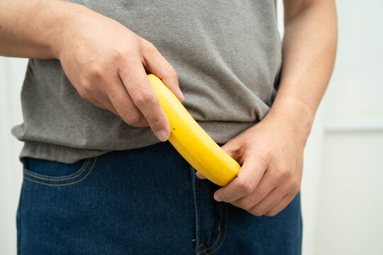 Male doctor stands holding a banana, penis health.