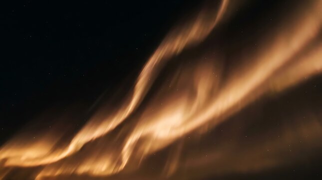 Vibrant golden aurora borealis waves dance gracefully across the deep dark night sky filled with tiny sparkling stars in this stunning long exposure celestial photograph