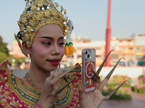 Thai Classical Dancer Applying Lipstick Using Smartphone as a Mirror
