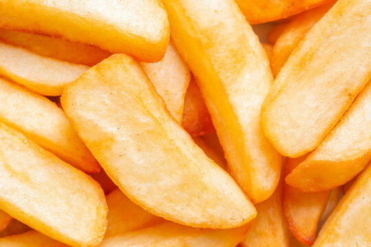 Tripled cooked fried chips background backdrop. Traditional British fried food concept.