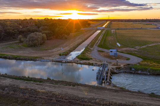 Aerial view of a golden sunset over over an irrigation channel and farmland