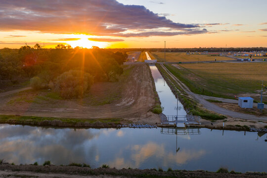 Aerial view of a golden sunset over over an irrigation channel and farmland