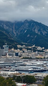 Coastal city harbor beneath dramatic mountains