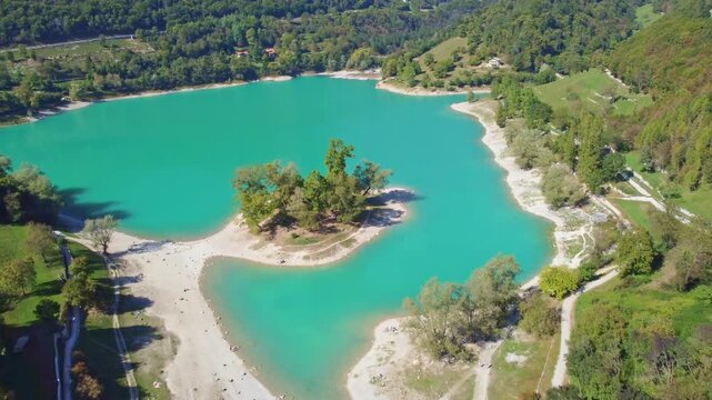 The clip shows an aerial view of Tenno Lake, surrounded by alpine terrain and lush natural landscape. Ideal for themes related to nature, travel, tourism, outdoor scenery and environmental projects.
