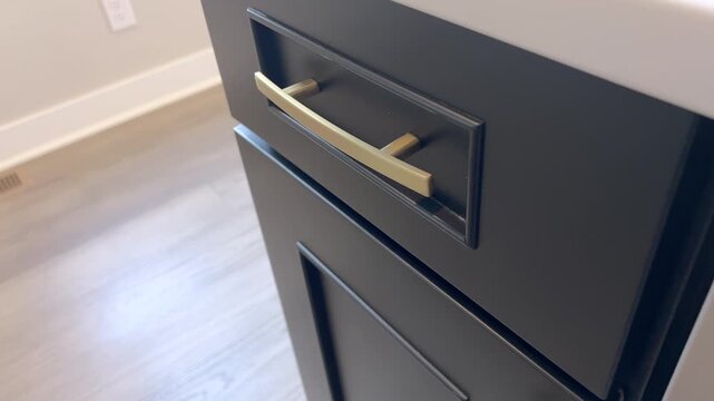 Close-up of dark drawer with gold handle