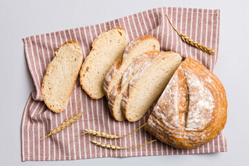 Obraz premium Freshly baked bread slices on napkin against natural background. top view Sliced bread