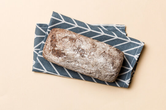 Fresh rye bread on napkin on rustic background, fresh bread top view