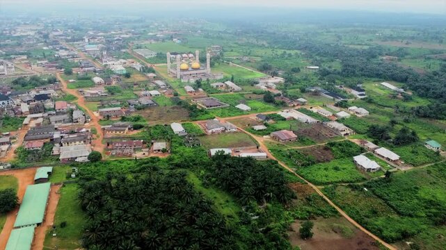 Aerial view of the mosque with golden domes surrounded by lush greenery and residential buildings in Aiyepe, Ogun State, Nigeria.