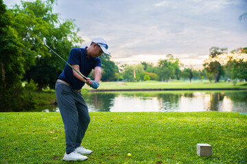 Obraz premium Confident golfer preparing to tee off on green grass fairway
