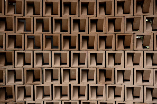 Texture of a wall made from brown terracotta roster ventilation blocks arranged in a geometric pattern