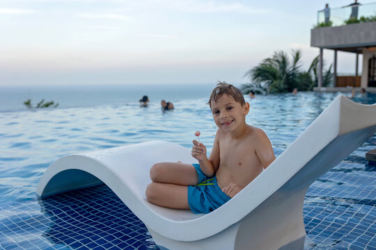 Child with mother in swimming pool, enjoying hppy family summer vacation on the beach and in resort