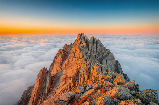 Mountain Summit Emerging Above Unbroken Sea of Clouds Like a Rocky Island