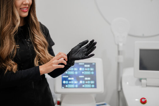 Aesthetics practitioner wearing black medical gloves before skin procedure